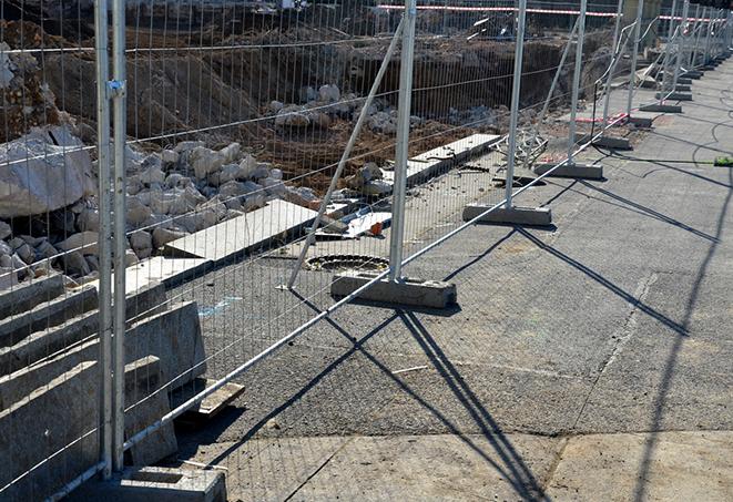 construction workers unloading temporary fence panels for their job site